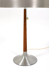 Bordslampa  av Svend Aage Holm Sørensen för ASEA, 1960tal. Denna lampa har en elegant och stilren design, tillverkad av borstad aluminium och teak. Lampans skärm har lite bruksslitage.