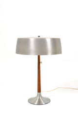 Bordslampa  av Svend Aage Holm Sørensen för ASEA, 1960tal. Denna lampa har en elegant och stilren design, tillverkad av borstad aluminium och teak. Lampans skärm har lite bruksslitage.