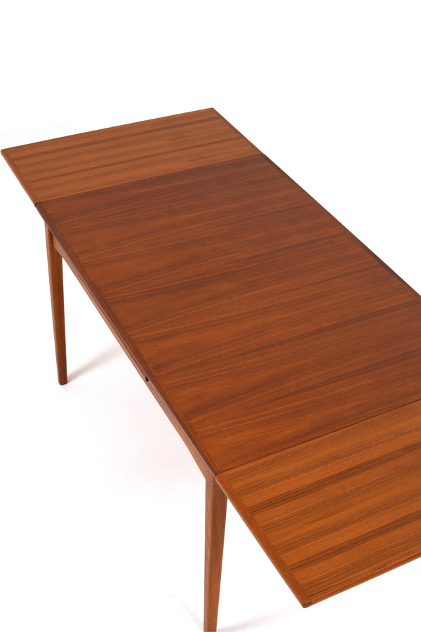 Matbord i teak från 60talet. Bordet är i färgen brunt med holländskt utdrag. Runt bordet ser man fyra stycken matstolar från matstolar "Modell 78" av Niels Otto Møller för J. L. Møller