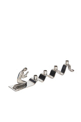 Adventsljusstake av Walter Andersson för Ystad Metall i krom. I ena änden återges en stiliserad knäböjande figur i bön med subtila art déco-influenser.