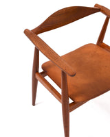 Karmstol av Hans J Wegner i massiv brunt teak. Sits klädd i brunt läder, med patina.