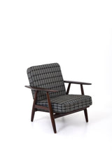 Fåtölj i brunt trä med dynor i rutigt tyg. Fåtölj GE-240 "Cigarren" av Hans J. Wegner för Getama