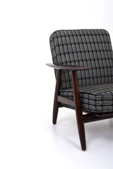 Fåtölj i brunt trä med dynor i rutigt tyg. Fåtölj GE-240 "Cigarren" av Hans J. Wegner för Getama