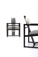 Svart fåtölj rutigt tyg beigt ulltyg konstverk