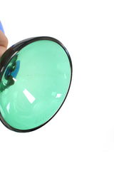 Blå glasskål på fot som är i grönt glas.
