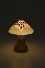 Bordslampa i forma av en svamp i glas. Färgerna brunt, orange, vitt och mörkgrönt.