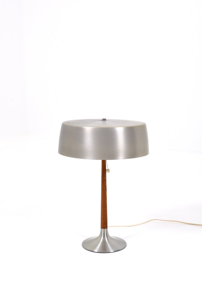 Bordslampa  av Svend Aage Holm Sørensen för ASEA, 1960tal. Denna lampa har en elegant och stilren design, tillverkad av borstad aluminium och teak. Lampans skärm har lite bruksslitage. 