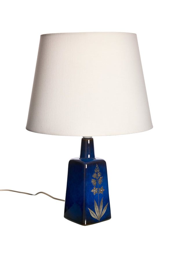 Bordslampa med blå glasyr och intarsia av botaniska motivet i silver på framsidan.