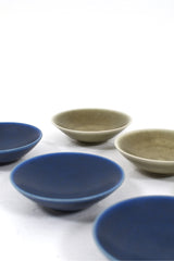 Sex stycken små keramikskålar med harpälsglasyr i blått och grönt.
