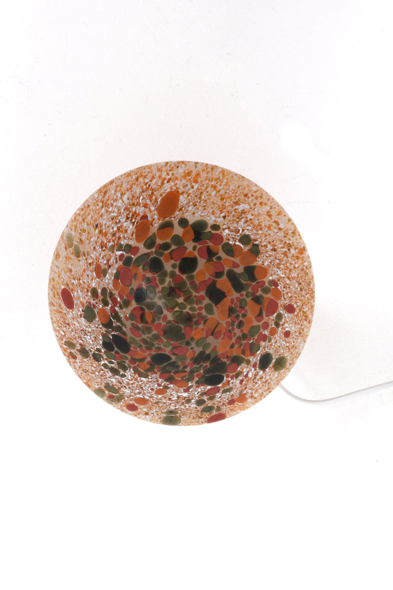 Bordslampa i forma av en svamp i glas. Färgerna brunt, orange, vitt och mörkgrönt.