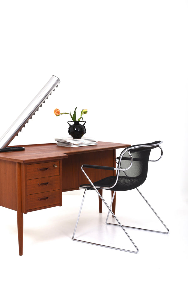 Skrivbord med njurformad svängd skiva i brunt träslag teak.